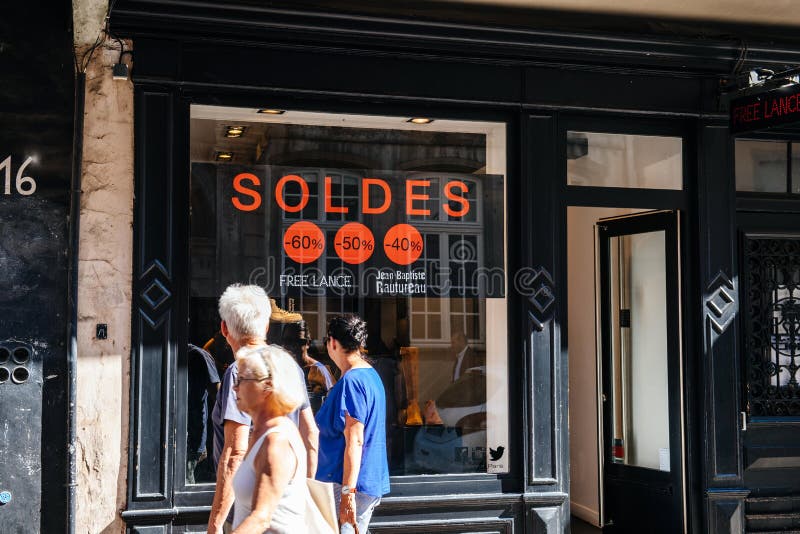 Folk som framme går av Soldes försäljningar framme av fönstret arkivbilder Folk som framme går av Soldes försäljningar framme av fönstret arkivbilder