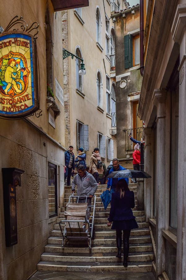 Folk som går på smal trappuppgång mellan byggnader i staden av Venedig, Italien arkivfoto Folk som går på smal trappuppgång mellan byggnader i staden av Venedig, Italien arkivfoto