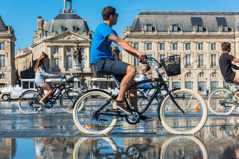 Folk som rider cyklar i springbrunnen i Bordeaux, Frankrike