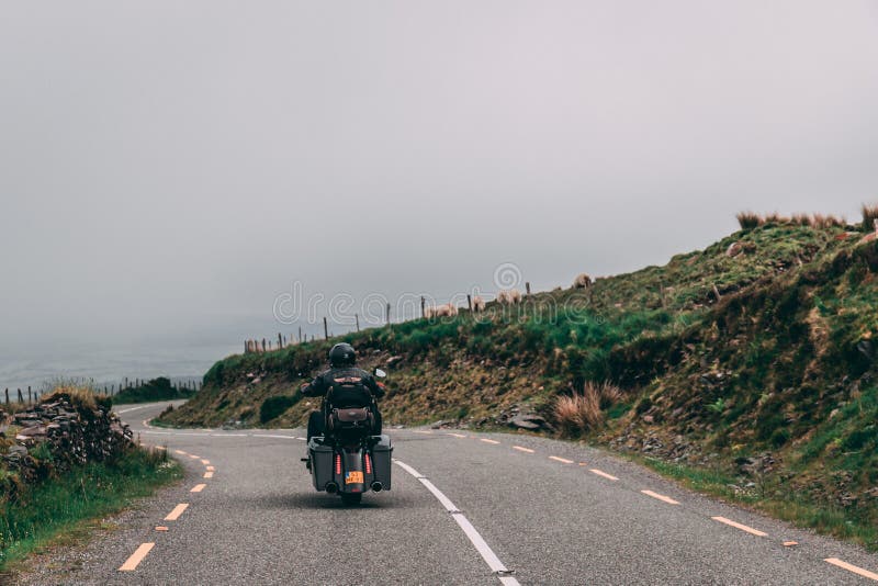 Folk som rider i motorcyklar längs den sceniska vägen till Conor Pass i ståndsmässiga Kerry, Irland arkivfoto Folk som rider i motorcyklar längs den sceniska vägen till Conor Pass i ståndsmässiga Kerry, Irland arkivfoto