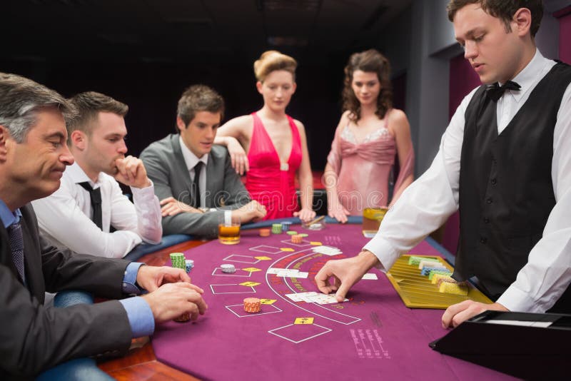 Folk som ser återförsäljaren som handlar blackjackkort arkivbilder Folk som ser återförsäljaren som handlar blackjackkort arkivbilder