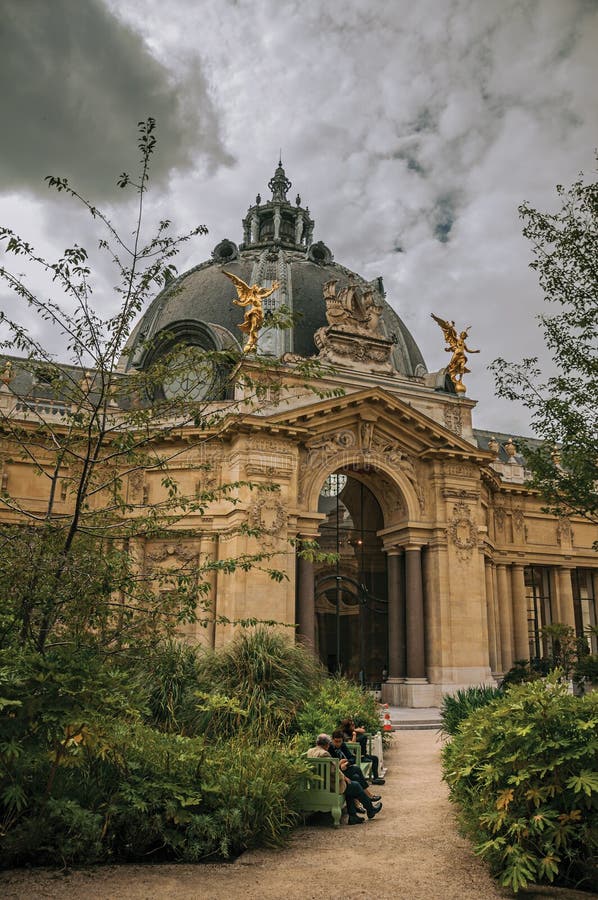 Folk som sitter på bänkar i Petit Palaisborggården i Paris arkivfoto Folk som sitter på bänkar i Petit Palaisborggården i Paris arkivfoto