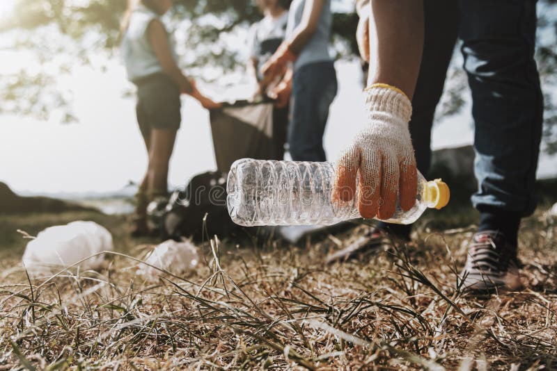 folk som upp väljer avskräde och sätter den i den plast- svarta påsen för att göra ren arkivbild folk som upp väljer avskräde och sätter den i den plast- svarta påsen för att göra ren arkivbild