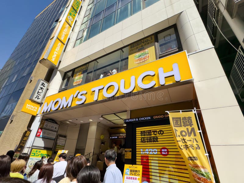 TOKYO, JAPAN - APRIL 19, 2024: People are waiting in line in front of newly opened Mom's Touch restaurant in Shibuya, Tokyo. Mom's Touch is a chicken burger chain based in South Korea. TOKYO, JAPAN - APRIL 19, 2024: People are waiting in line in front of newly opened Mom's Touch restaurant in Shibuya, Tokyo. Mom's Touch is a chicken burger chain based in South Korea.