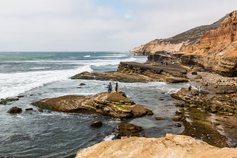 Folket undersöker tidvattentips i Point Loma, Kalifornien royaltyfri bild Folket undersöker tidvattentips i Point Loma, Kalifornien royaltyfri bild