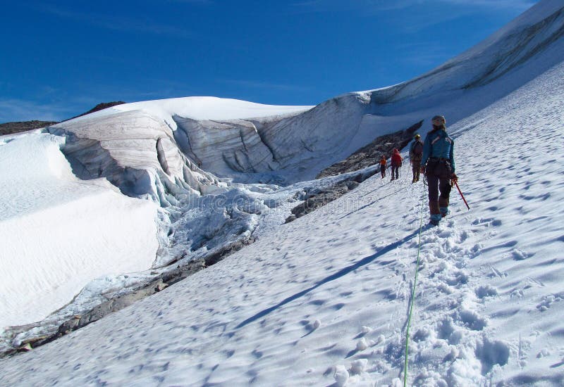 People climbers, climbing and trekking with big backpack and alpinist equipment - ice axe, crampons and rope .. Beautiful scenery, the view of a landscape of snow summit, rocky mountain peaks and glacier in Norway. Lake covered with snow and ice, iceberg, deep blue clear water, sunny day, blue sky with some clouds. Norwegian mountains of Jotunheim national park. People climbers, climbing and trekking with big backpack and alpinist equipment - ice axe, crampons and rope .. Beautiful scenery, the view of a landscape of snow summit, rocky mountain peaks and glacier in Norway. Lake covered with snow and ice, iceberg, deep blue clear water, sunny day, blue sky with some clouds. Norwegian mountains of Jotunheim national park.