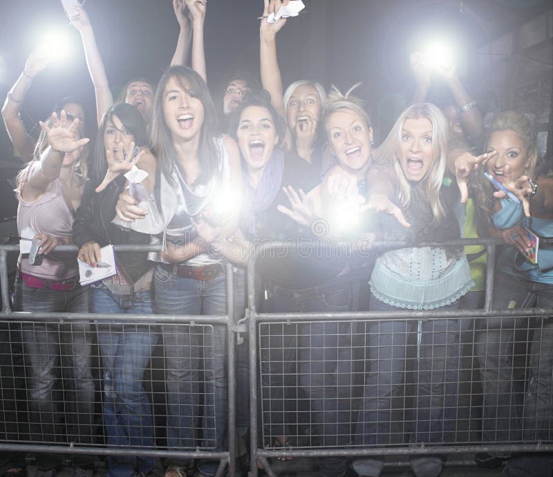 Crowd of young female fans screaming and cheering at concert. Crowd of young female fans screaming and cheering at concert