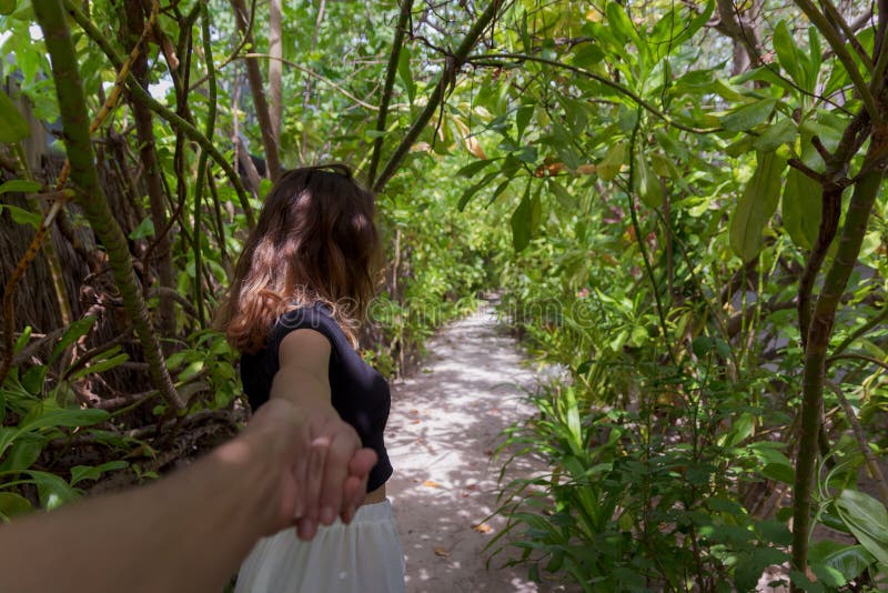 Follow-mekonzept der jungen Frau gehend auf einen Weg umgeben durch grüne Vegetation lizenzfreie stockfotos Follow-mekonzept der jungen Frau gehend auf einen Weg umgeben durch grüne Vegetation lizenzfreie stockfotos