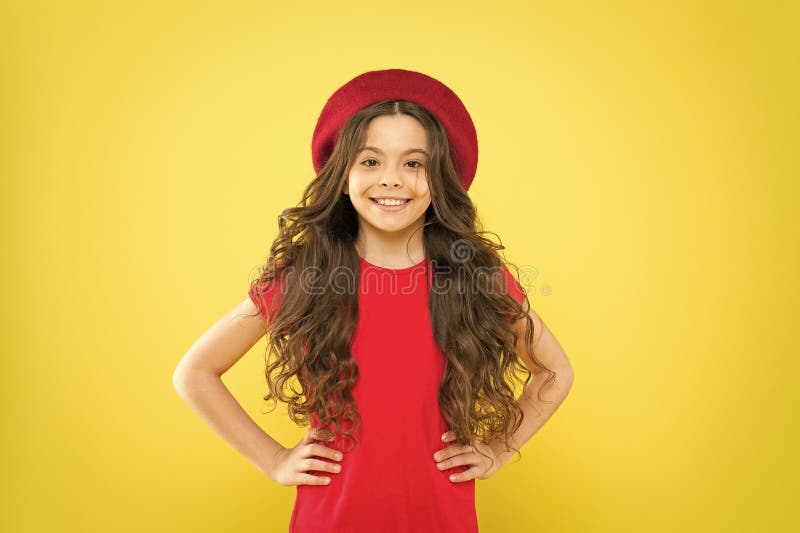 Following her personal style. little girl in french style hat. happy girl with long curly hair in beret. parisian child royalty free stock photos
