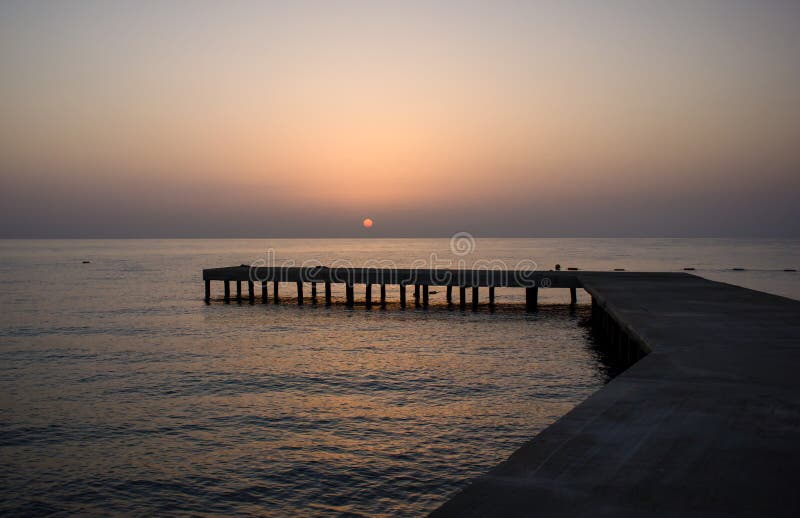 Fond avec la vieille jetée en bois en mer au coucher du soleil images libres de droits Fond avec la vieille jetée en bois en mer au coucher du soleil images libres de droits