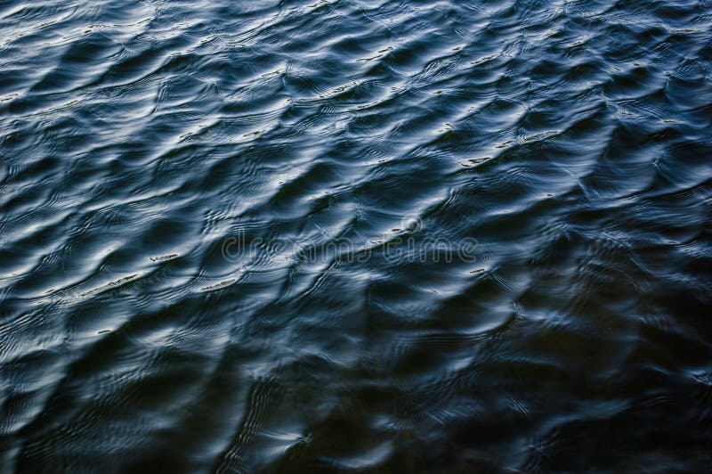 Fond bleu-foncé profond de l'eau d'ondulation de texture de surface de rivière photographie stock libre de droits