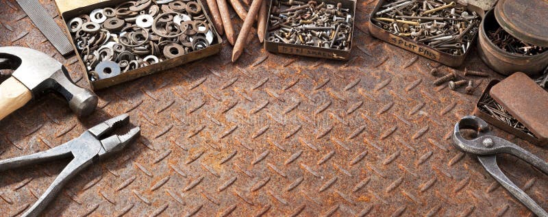 A background rusty metal surface with tools, nails and screws in old tin boxes. A background rusty metal surface with tools, nails and screws in old tin boxes