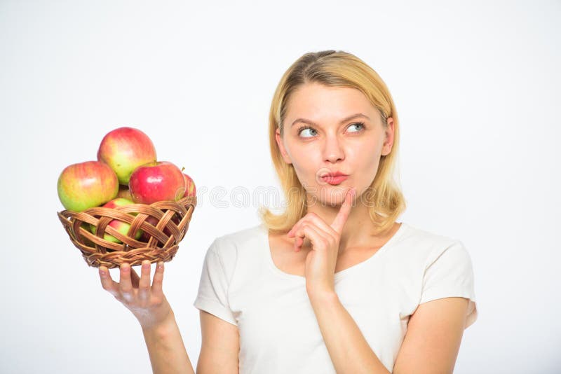 Fond de blanc de pommes de panier de prise de fille Concept culinaire de recette Le visage réfléchi de femme proposent l'idée quo photos libres de droits Fond de blanc de pommes de panier de prise de fille Concept culinaire de recette Le visage réfléchi de femme proposent l'idée quo photos libres de droits