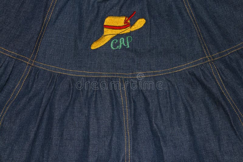 Fond de denim avec le chapeau jaune brodé photos libres de droits Fond de denim avec le chapeau jaune brodé photos libres de droits