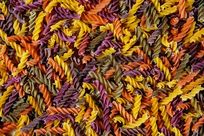 Fond de nourriture - pâtes de couleur trois crues de blé dur de Fusilli avec les épinards et la tomate