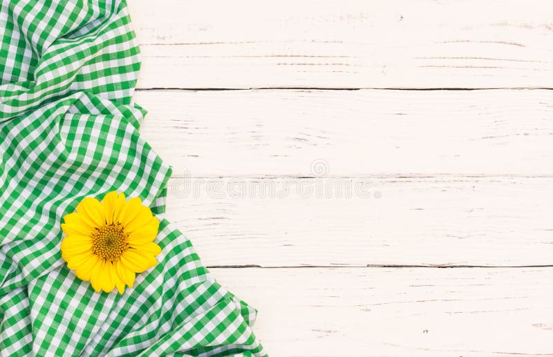 Green checked tablecloth with blossom on white wooden background with copy space. Green checked tablecloth with blossom on white wooden background with copy space