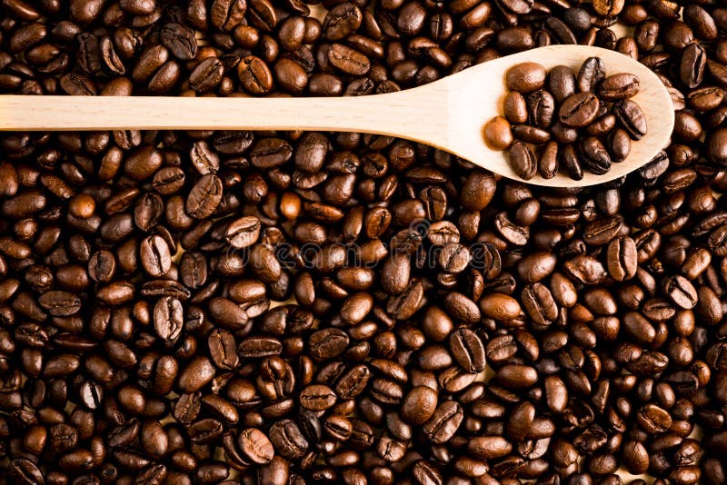 Fond et texture rôtis de grain de café avec la cuillère en bois, Co photos stock Fond et texture rôtis de grain de café avec la cuillère en bois, Co photos stock
