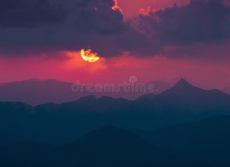 Fond foncé avec le soleil et des nuages au-dessus des montagnes lointaines image libre de droits Fond foncé avec le soleil et des nuages au-dessus des montagnes lointaines image libre de droits