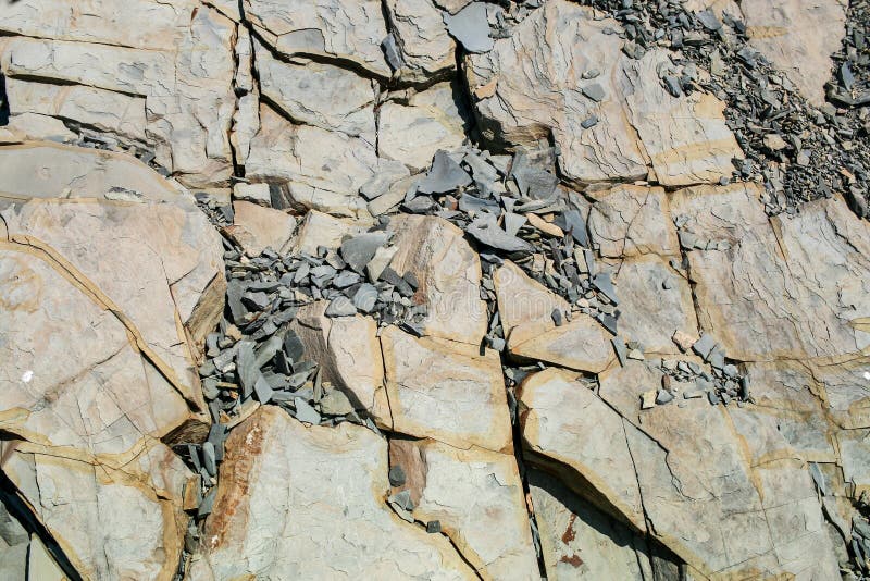 Natural gray-brown rocky inhomogeneous background of shale stones of different sizes. Natural gray-brown rocky inhomogeneous background of shale stones of different sizes.