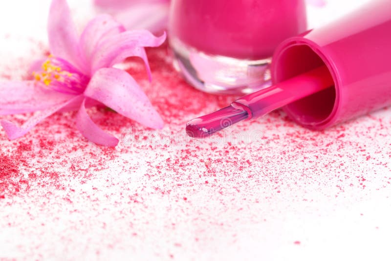 Pink nail polish close up, ground foundation and make up with pink blossom on white background. Girly fashion in pink and white. Pink nail polish close up, ground foundation and make up with pink blossom on white background. Girly fashion in pink and white.