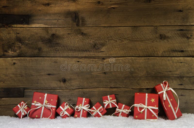 Fond rustique en bois avec des cadeaux de Noël rouges. images stock