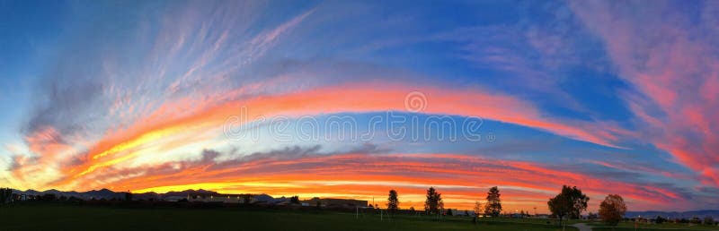 Fond saisissant panoramique de coucher du soleil avec orange, bleu vif, rouge et jaune, sous forme d'arc-en-ciel image libre de droits Fond saisissant panoramique de coucher du soleil avec orange, bleu vif, rouge et jaune, sous forme d'arc-en-ciel image libre de droits