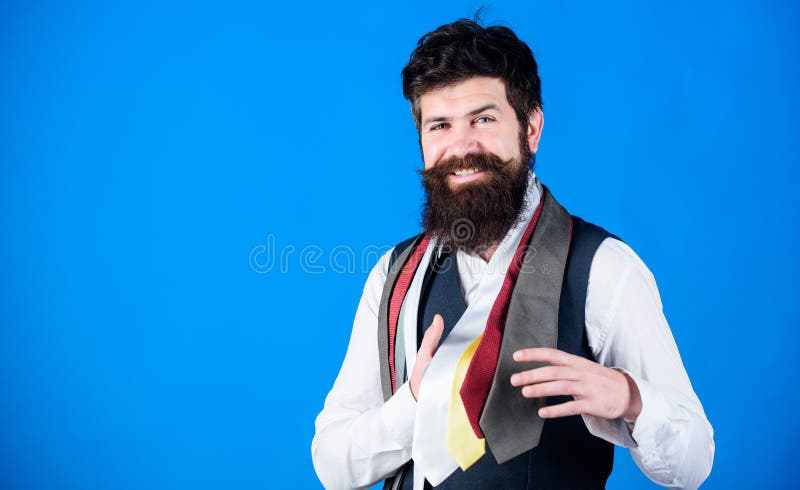 He is fond of shopping. Happy shop assistant offering wide choice of neckties for shopping. Bearded shopper choosing necktie in shopping mall. Hipster shopping the latest tie collection, copy space.