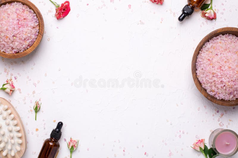 Fondo bianco con sale da bagno, il massaggiatore e le bottiglie di olio naturali fotografia stock libera da diritti Fondo bianco con sale da bagno, il massaggiatore e le bottiglie di olio naturali fotografia stock libera da diritti