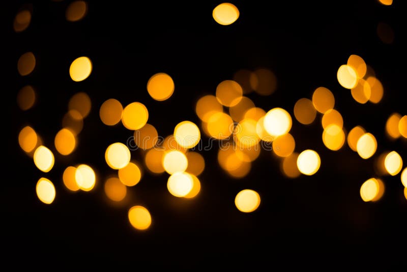Fondo borroso Las luces de Navidad en un fondo negro Bombillas amarillas fotografía de archivo Fondo borroso Las luces de Navidad en un fondo negro Bombillas amarillas fotografía de archivo