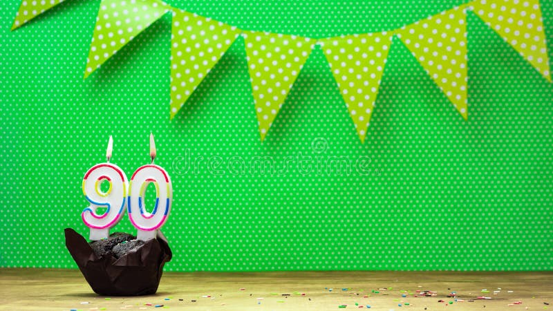 Colorful background happy birthday with decorations festive garlands with muffin on a green background with polka dots. Copy space. Beautiful happy birthday background with burning candles with number 90. Colorful background happy birthday with decorations festive garlands with muffin on a green background with polka dots. Copy space. Beautiful happy birthday background with burning candles with number 90