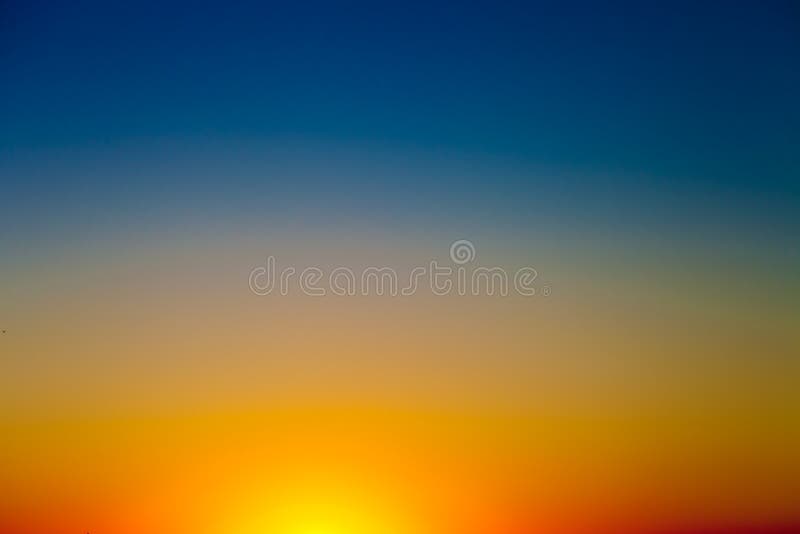 Fondo con el cielo de la puesta del sol de la pendiente en tonos del amarillo, de la naranja y del azul imagenes de archivo Fondo con el cielo de la puesta del sol de la pendiente en tonos del amarillo, de la naranja y del azul imagenes de archivo
