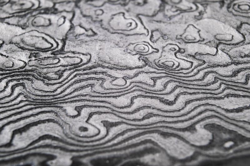Fondo con el modelo del acero del damasco Cierre para arriba Tiro macro de una textura de la cuchilla de cuchillo de Damasco Mode foto de archivo libre de regalías Fondo con el modelo del acero del damasco Cierre para arriba Tiro macro de una textura de la cuchilla de cuchillo de Damasco Mode foto de archivo libre de regalías