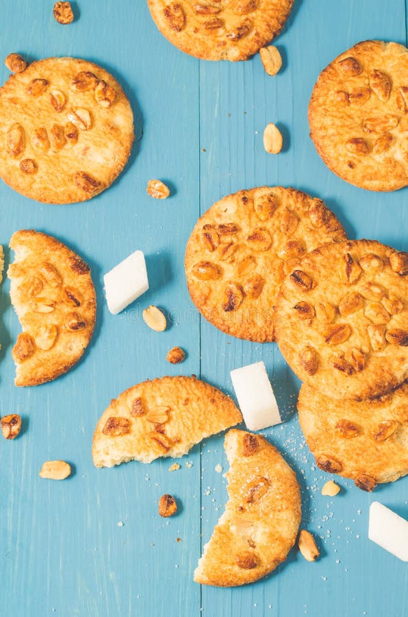 Fondo con i biscotti con i dadi e lo zucchero di grumo su un woode blu fotografia stock libera da diritti Fondo con i biscotti con i dadi e lo zucchero di grumo su un woode blu fotografia stock libera da diritti