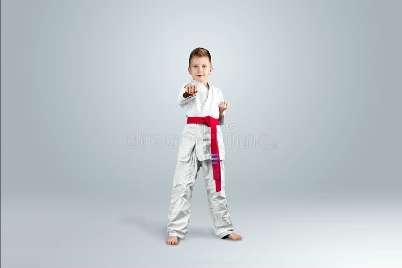Fondo creativo, bambino in kimono bianco su un fondo leggero Il concetto delle arti marziali, karat?, sport da allora immagine stock Fondo creativo, bambino in kimono bianco su un fondo leggero Il concetto delle arti marziali, karat?, sport da allora immagine stock