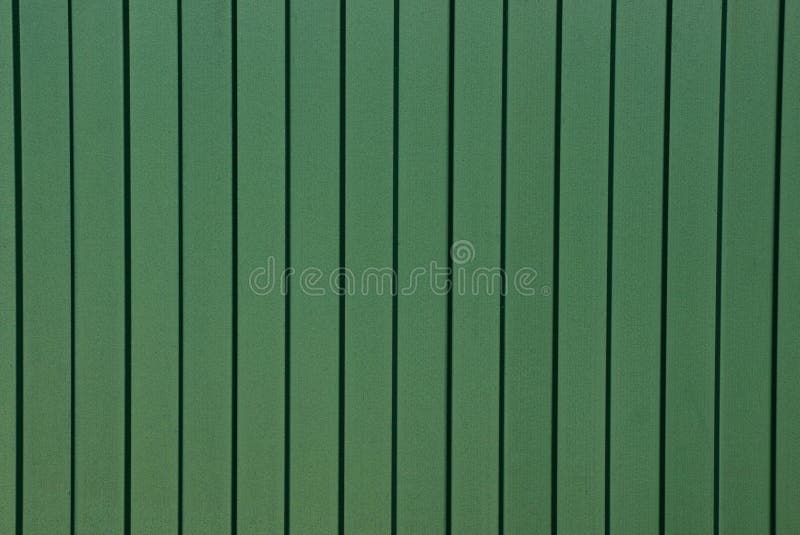 Fondo da un frammento di una parete verde del metallo di un recinto fotografie stock Fondo da un frammento di una parete verde del metallo di un recinto fotografie stock