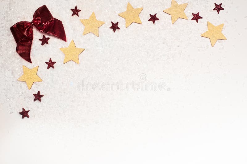 Fondo de la Navidad, con las estrellas del brillo del oro, el arco rojo, y la nieve foto de archivo Fondo de la Navidad, con las estrellas del brillo del oro, el arco rojo, y la nieve foto de archivo