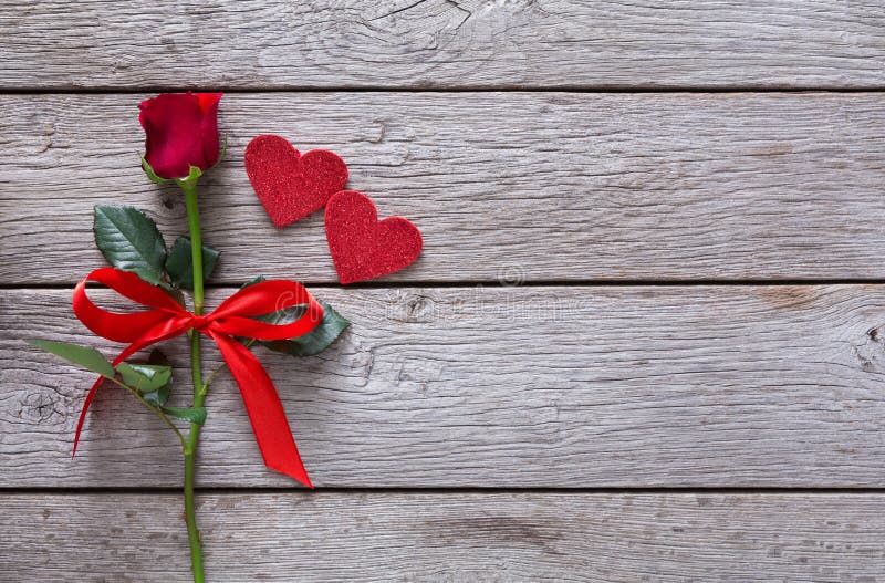 Fondo de la tarjeta del día de San Valentín con la flor de la rosa del rojo, corazones de papel en la madera rústica fotografía de archivo libre de regalías Fondo de la tarjeta del día de San Valentín con la flor de la rosa del rojo, corazones de papel en la madera rústica fotografía de archivo libre de regalías