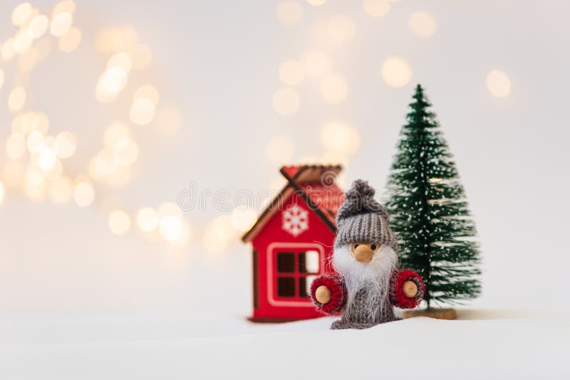 Christmas background with fir tree, house and toy man against defocused lights. Christmas or New Year celebration concept. Copy space. Christmas background with fir tree, house and toy man against defocused lights. Christmas or New Year celebration concept. Copy space.