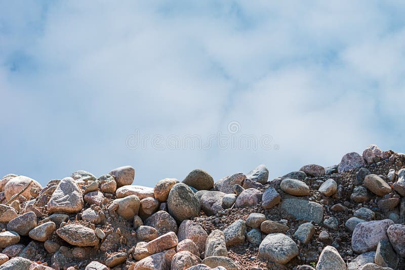 Fondo de una pila de guijarros y del cielo con las nubes imagen de archivo libre de regalías Fondo de una pila de guijarros y del cielo con las nubes imagen de archivo libre de regalías