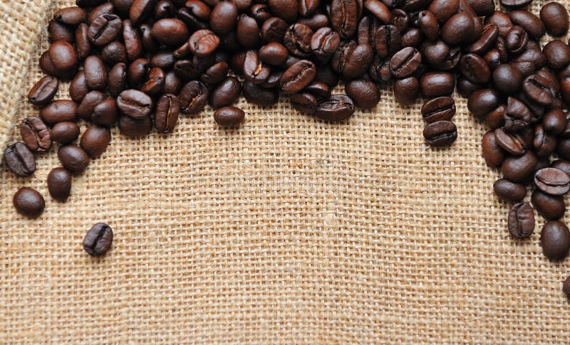 Fondo dei chicchi di caffè e della tela fotografia stock Fondo dei chicchi di caffè e della tela fotografia stock