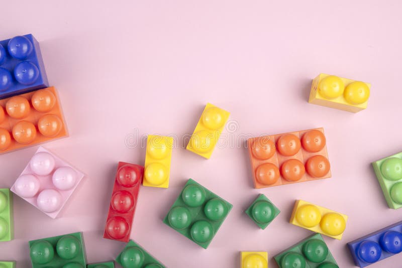 Fondo dei giocattoli dei bambini con i blocchi variopinti che mettono sulla tavola rosa Copi lo spazio per testo immagini stock libere da diritti Fondo dei giocattoli dei bambini con i blocchi variopinti che mettono sulla tavola rosa Copi lo spazio per testo immagini stock libere da diritti