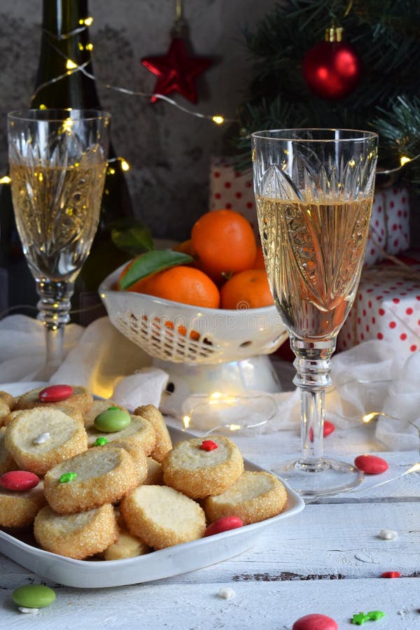 Fondo del concepto de la Navidad y de la celebración del día de fiesta del Año Nuevo Vidrio de champán, mandarinas, galletas hech imagen de archivo Fondo del concepto de la Navidad y de la celebración del día de fiesta del Año Nuevo Vidrio de champán, mandarinas, galletas hech imagen de archivo