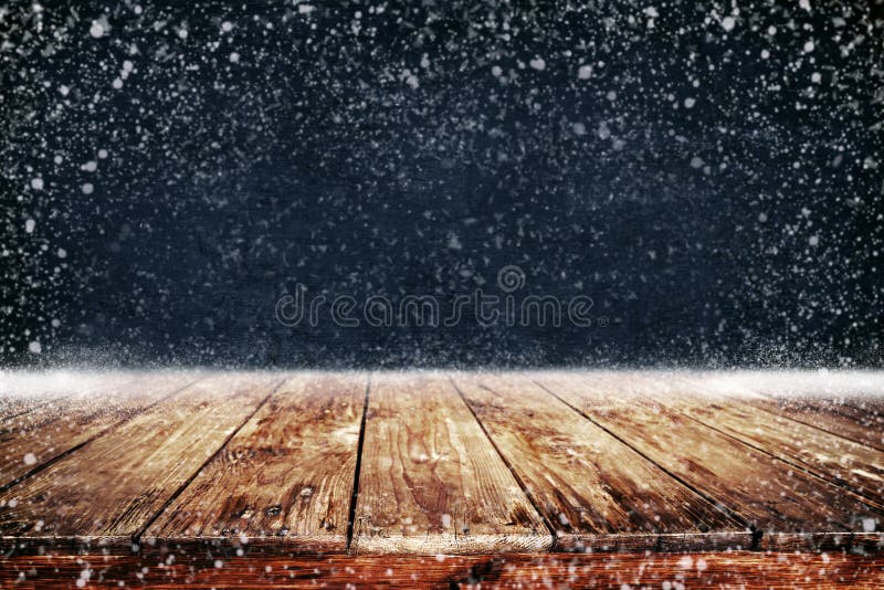 Fondo del nuovo anno e di Natale con la tavola e le precipitazioni nevose di legno della piattaforma fotografia stock Fondo del nuovo anno e di Natale con la tavola e le precipitazioni nevose di legno della piattaforma fotografia stock