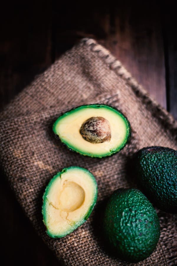 Fondo dell'alimento con l'avocado organico fresco sulla vecchia tavola di legno, fotografia stock Fondo dell'alimento con l'avocado organico fresco sulla vecchia tavola di legno, fotografia stock