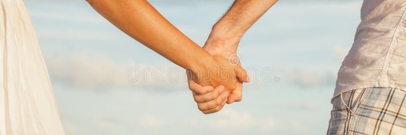 Fondo dell'insegna delle coppie che si tengono per mano che data la passeggiata romantica della spiaggia di tramonto fotografia stock libera da diritti Fondo dell'insegna delle coppie che si tengono per mano che data la passeggiata romantica della spiaggia di tramonto fotografia stock libera da diritti