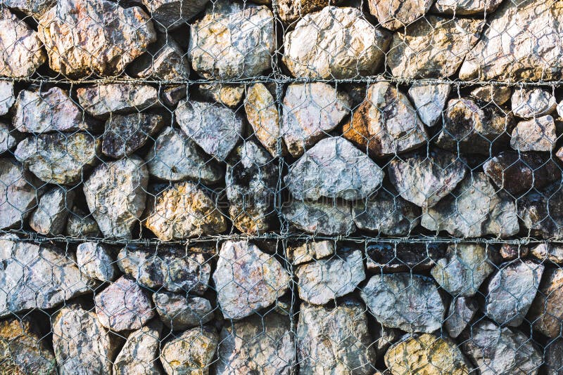 Fondo della parete di pietra e cavo della maglia immagine stock Fondo della parete di pietra e cavo della maglia immagine stock