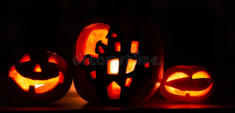 Fondo della zucca di Halloween dell'insegna, tre zucche con fondo nero scuro Due zucche e case affrontate spaventose immagini stock Fondo della zucca di Halloween dell'insegna, tre zucche con fondo nero scuro Due zucche e case affrontate spaventose immagini stock