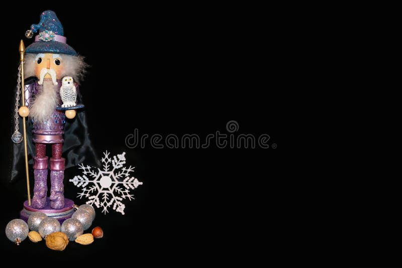 Fondo delle schiaccianoci dello stregone - figura porpora con il fiocco di neve ed i dadi e le palle di Natale, tenendo un person fotografia stock libera da diritti Fondo delle schiaccianoci dello stregone - figura porpora con il fiocco di neve ed i dadi e le palle di Natale, tenendo un person fotografia stock libera da diritti