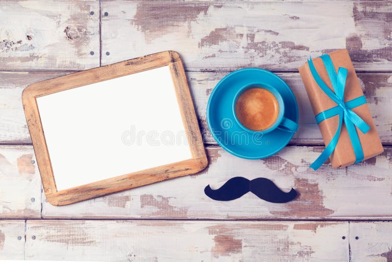 Fathers day background with photo frame, coffee cup and gift box on wooden table. View from above. Flat lay. Fathers day background with photo frame, coffee cup and gift box on wooden table. View from above. Flat lay