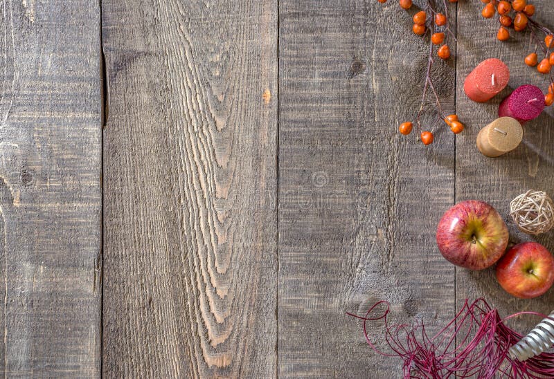 Fondo di legno rustico della plancia con le candele, le mele ed i ber di autunno immagine stock libera da diritti Fondo di legno rustico della plancia con le candele, le mele ed i ber di autunno immagine stock libera da diritti